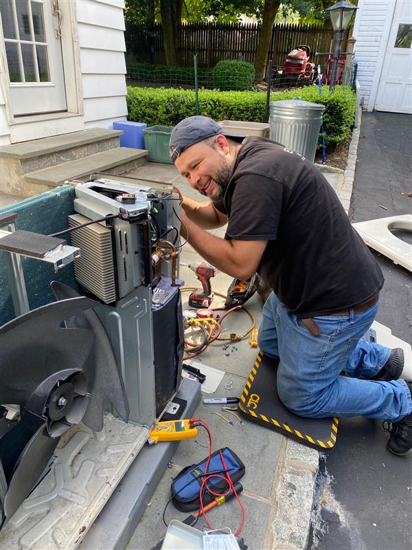 A man working on an air conditioner unit.