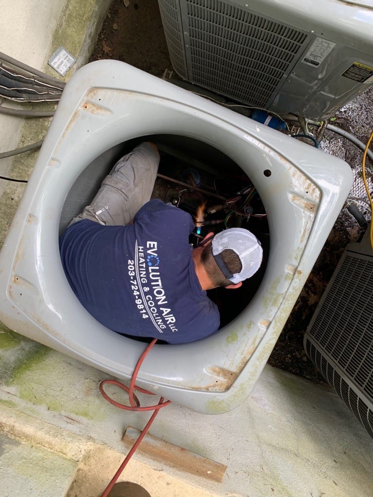 A man is in the hole of an old toilet.